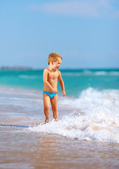 cute kid boy having fun in sea surf