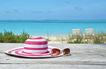 Obraz premium Hat and sunglasses on the beach of Exuma, Bahamas