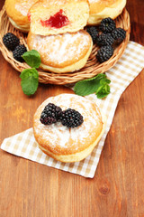Tasty donuts with berries on wooden table