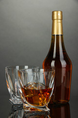 Glass of whiskey with bottle, on dark background