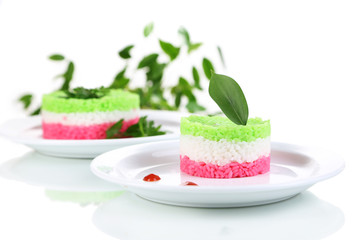Colored rice on plates isolated on white