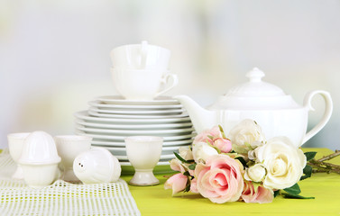 Lots beautiful dishes on wooden table on bright background