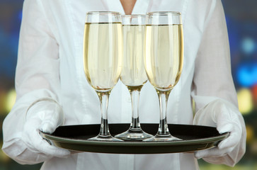 Waitresses holding tray with glasses of champagne
