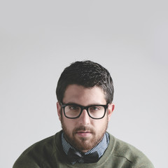Obraz premium Stylish young man wearing bowtie and glasses on grey Background.