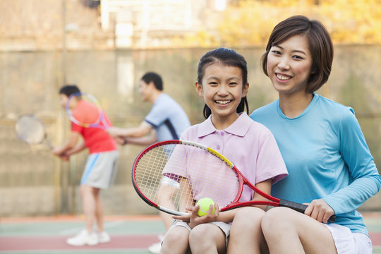 Mother and daughter playing tennis 