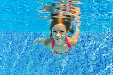 Happy active child swims underwater in pool, kids sport