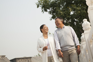 Senior couple walking outside in Beijing, tilt