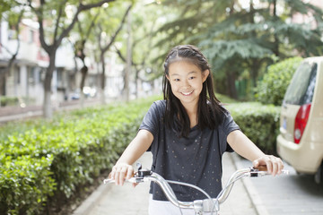 Obraz premium Young Girl Riding Her Bicycle