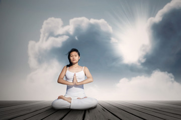 Fototapeta na wymiar Attractive girl exercise yoga under blue sky