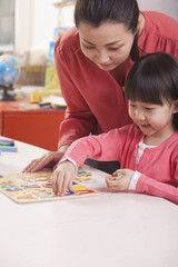 Teaching Helping Young Girl with Cut-Out Alphabet Letters