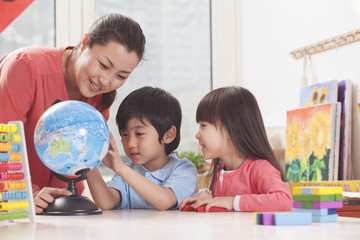 Fototapeta premium Students And Teacher Looking at Globe