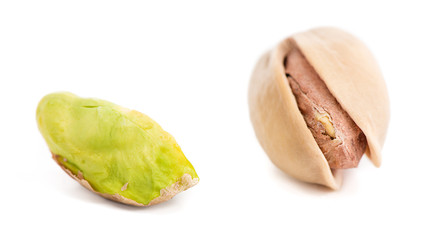 Two pistachios one open isolated on white background