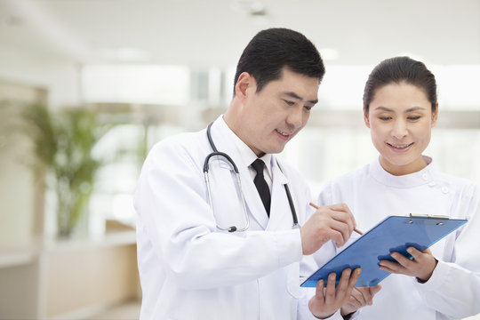 Doctor and Nurse Looking at Medical Record  