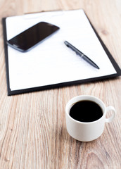 Obraz na płótnie Canvas Coffee cup with phone and documents