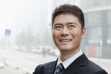 Young Businessman Smiling and Looking Up, Portrait