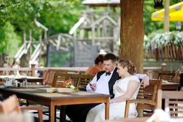 Fototapeta na wymiar Bride and groom having fun at cafe