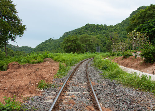 Train tracks curving along a mountain