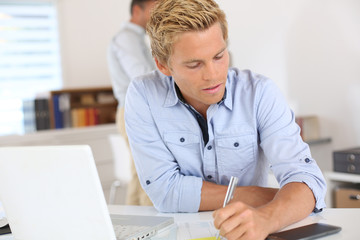 Portrait of smiling attractive young man in office