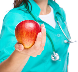 Lady doctor is holding a red apple