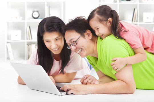 happy family with child looking at laptop