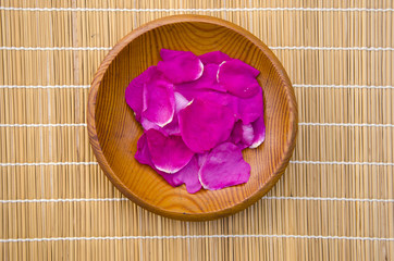 Fototapeta na wymiar wild rose eglantine petals in wooden plate