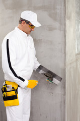 Worker mixing putty with a trowel