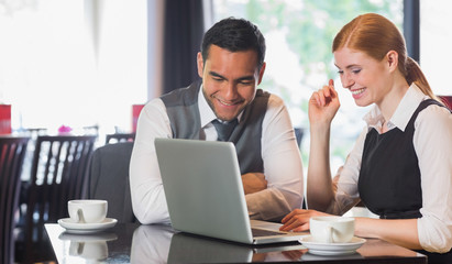Happy business team working together in a cafe
