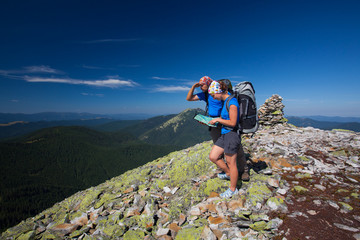 Obraz premium Caucasian couple takes rest on top of mountain