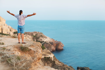 Man standing on a rock by the sea . Concept of freedom. 