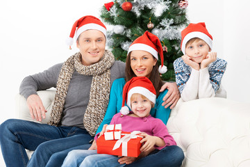 Obraz na płótnie Canvas Spending Christmas Eve together. Cheerful family sitting close t