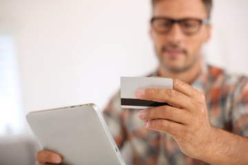 Trendy guy doing online shopping with tablet