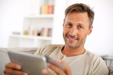 Handsome smiling man at home buying on internet