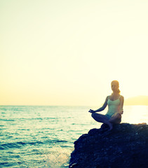 woman meditating in  lotus yoga on beach