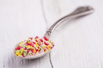 Spoon with sugar little candies