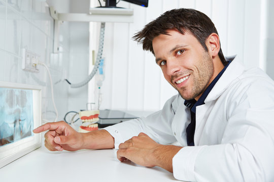Zahnarzt mit Röntgenbild in seiner Praxis