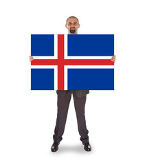 Smiling businessman holding a big card, flag of Iceland