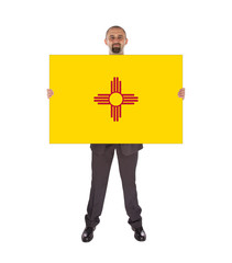Smiling businessman holding a big card, flag of New Mexico