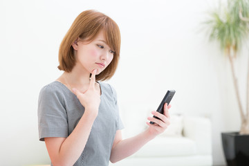 Naklejka premium スマートフォンを見る女性