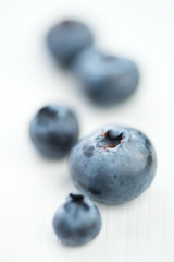 Ripe blueberries on white wooden background, vertical shot