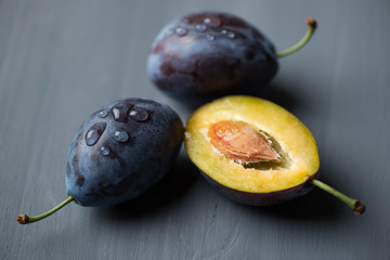 Fresh plums, grey wooden background, horizontal shot