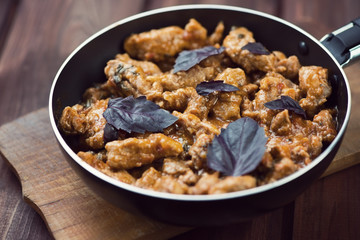 Roasted pork with basil leaves, close-up, horizontal shot