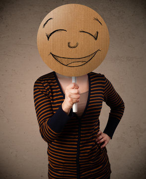 Young woman holding a smiley face board