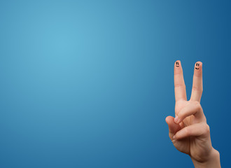 Happy smiley face fingers looking at empty blue background copy
