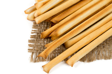bread sticks on burlap over white