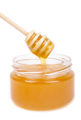 Honey dripping into a jar with a special spoon.
