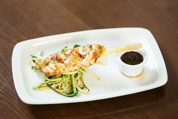 Asian inspired fish dish with noodles and julienne vegetables