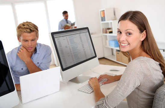 Portrait of smiling office worker in front of desktop