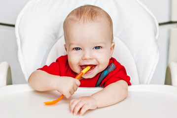 laughing boy holding a spoon