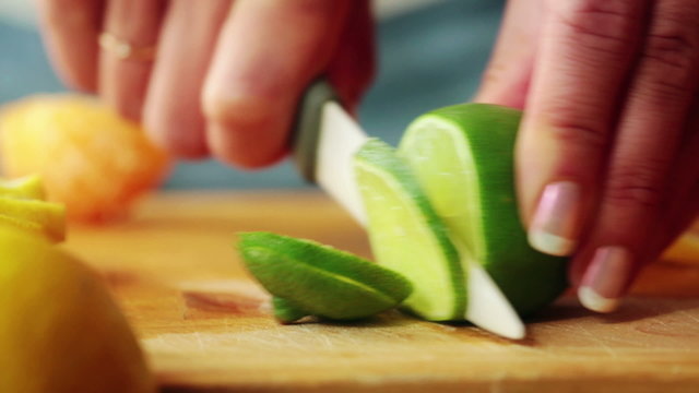Closeup of woman hands slicing lime
