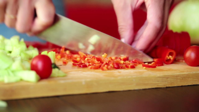 Woman hands slicing, chopping chili pepper in kitchen